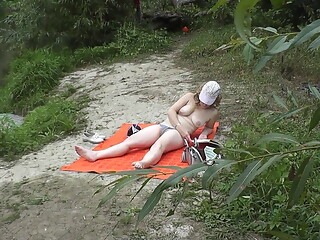 Wild beach. Random passerby guy peeps on river bank sunbathing topless beautiful Milf Outdoors. Outs