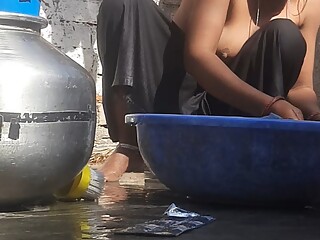 Indian stepsister is preparing to take a bath while washing clothes in the open courtyard of the hou